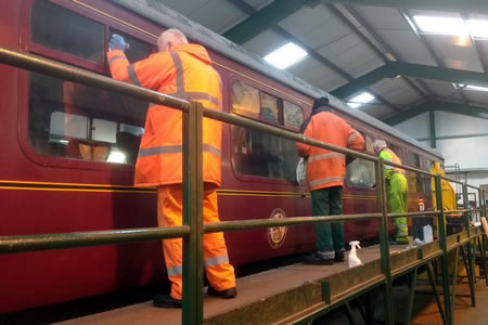 Photograph of volunteers preparing a carriage for painting